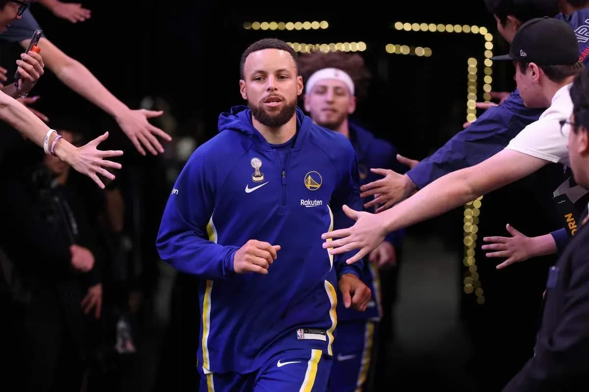 Stephen Curry corriendo hacia la cancha entre aficionados