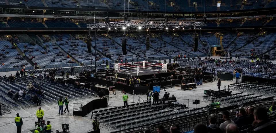 Ring de boxeo en estadio con espectadores asistentes