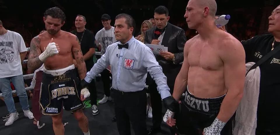 Boxeadores y árbitro en el ring después de la pelea