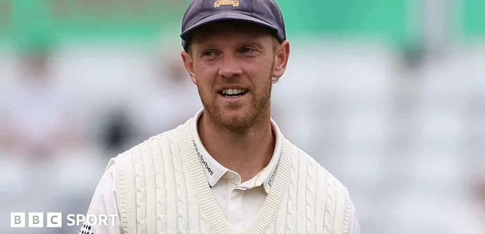 Jugador de cricket con jersey blanco sonriendo