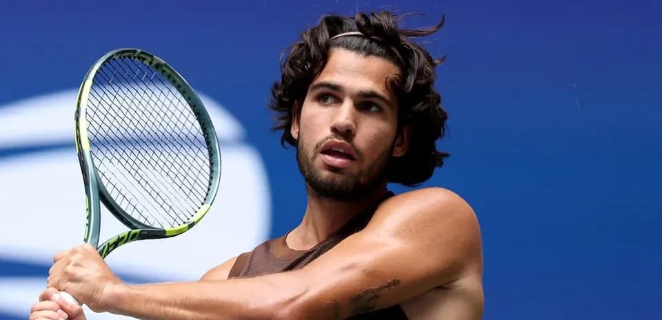 Jugador de tenis sosteniendo una raqueta en la cancha