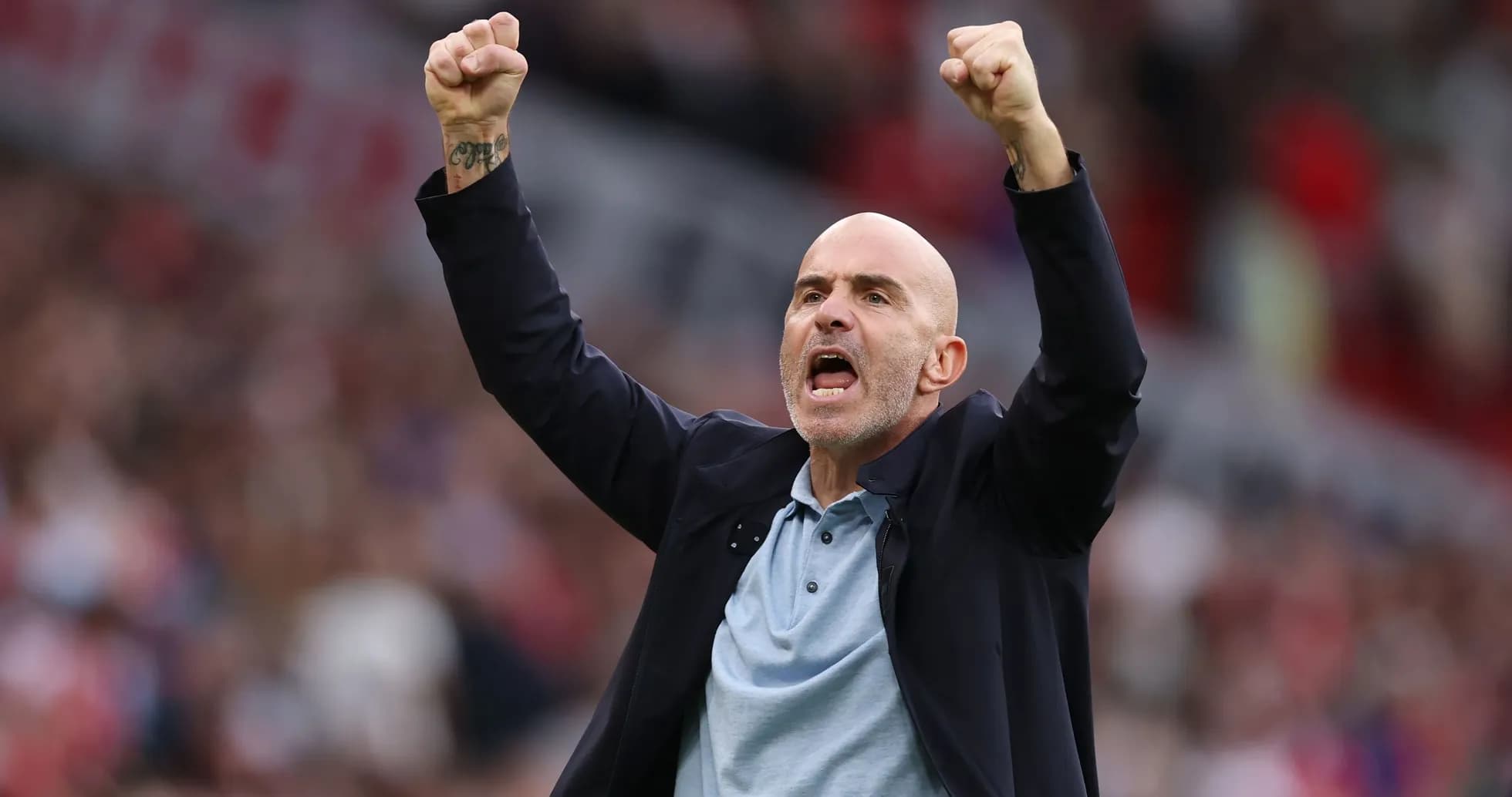 Entrenador celebrando con los brazos levantados