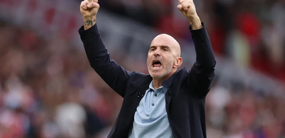 Entrenador celebrando con los brazos levantados