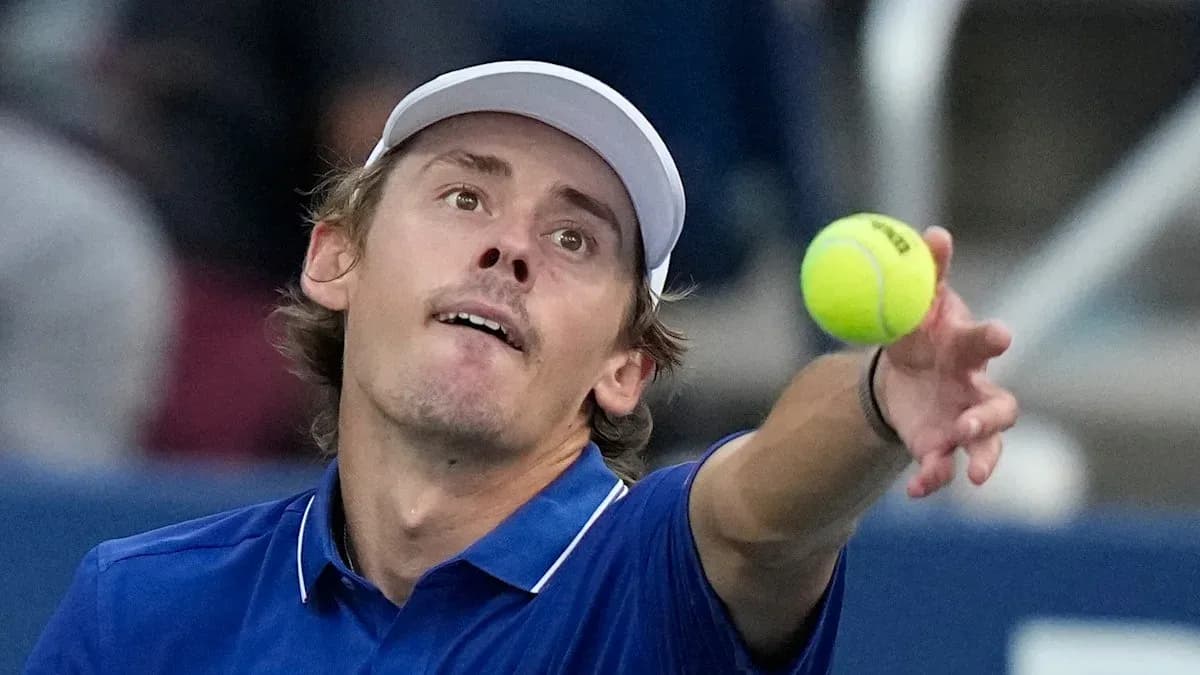 Jugador lanzando la pelota durante un saque de tenis
