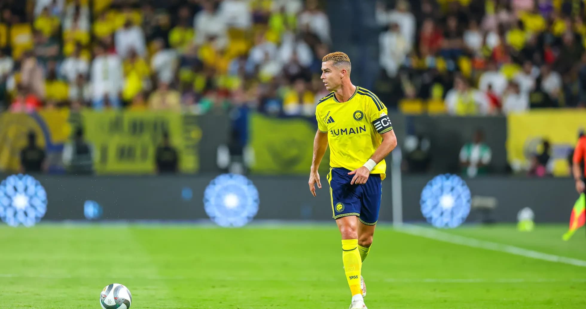 Jugador corriendo con balón en campo de fútbol