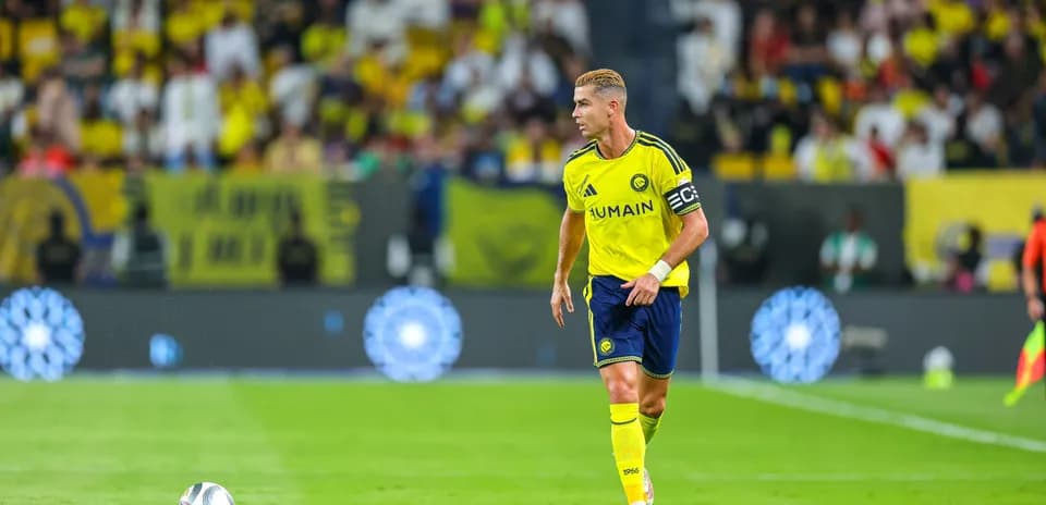 Jugador corriendo con balón en campo de fútbol