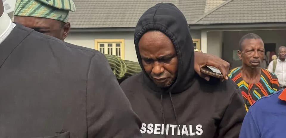 Hombre con sudadera negra siendo acompañado por otros