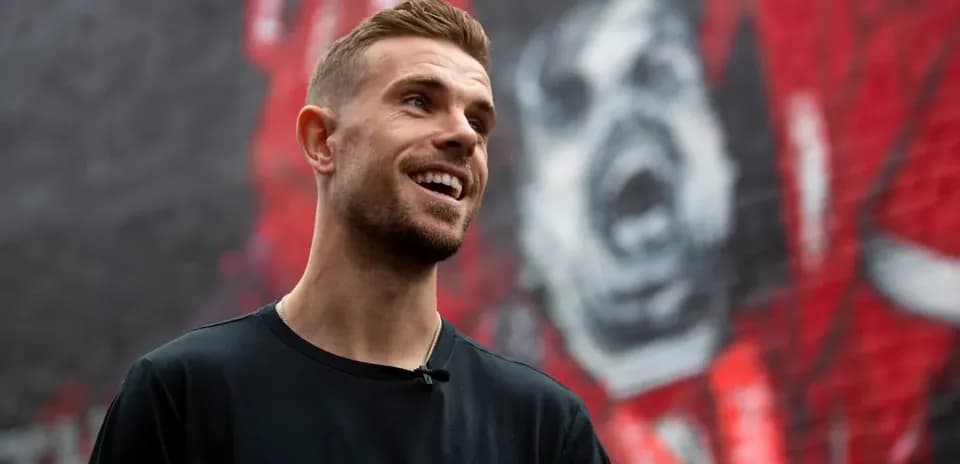 Jugador sonriendo frente a mural en la pared