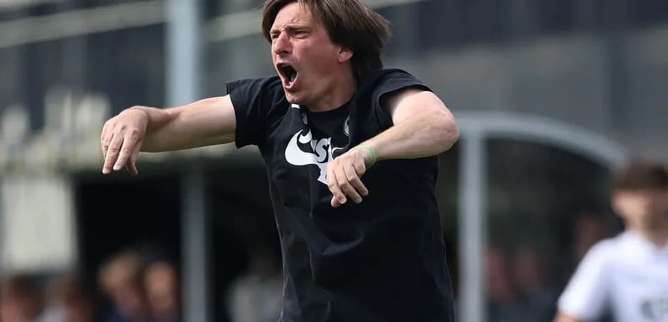 Entrenador dirigiendo desde la línea de banda