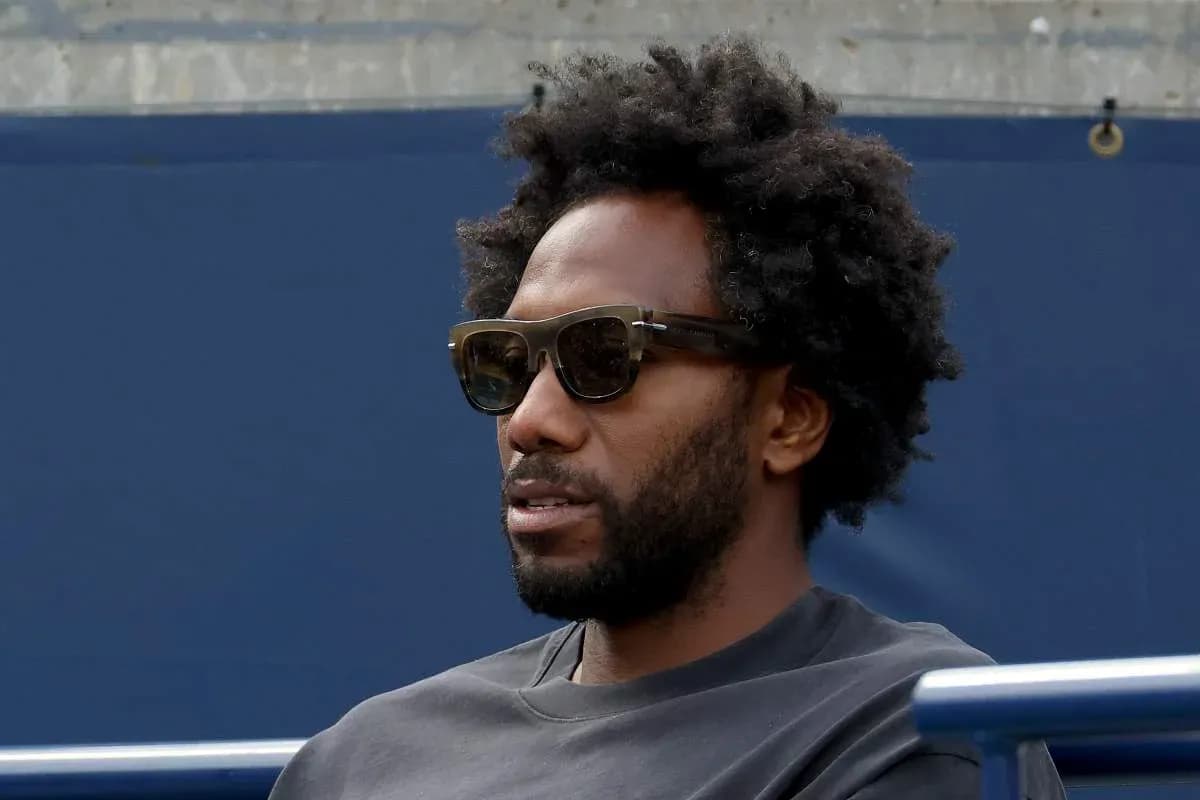 Hombre con gafas oscuras sentado en un estadio