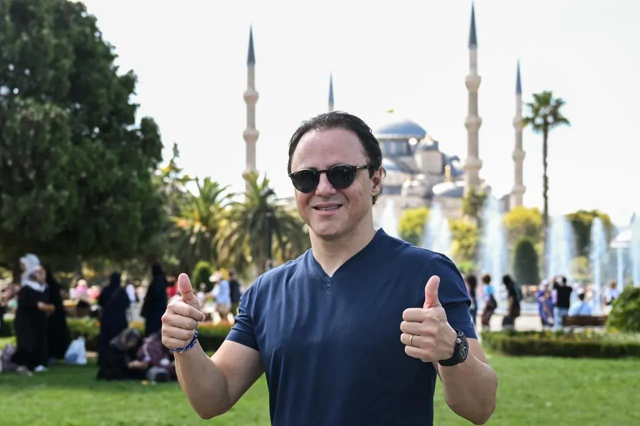 Hombre sonriendo con pulgares hacia arriba en parque