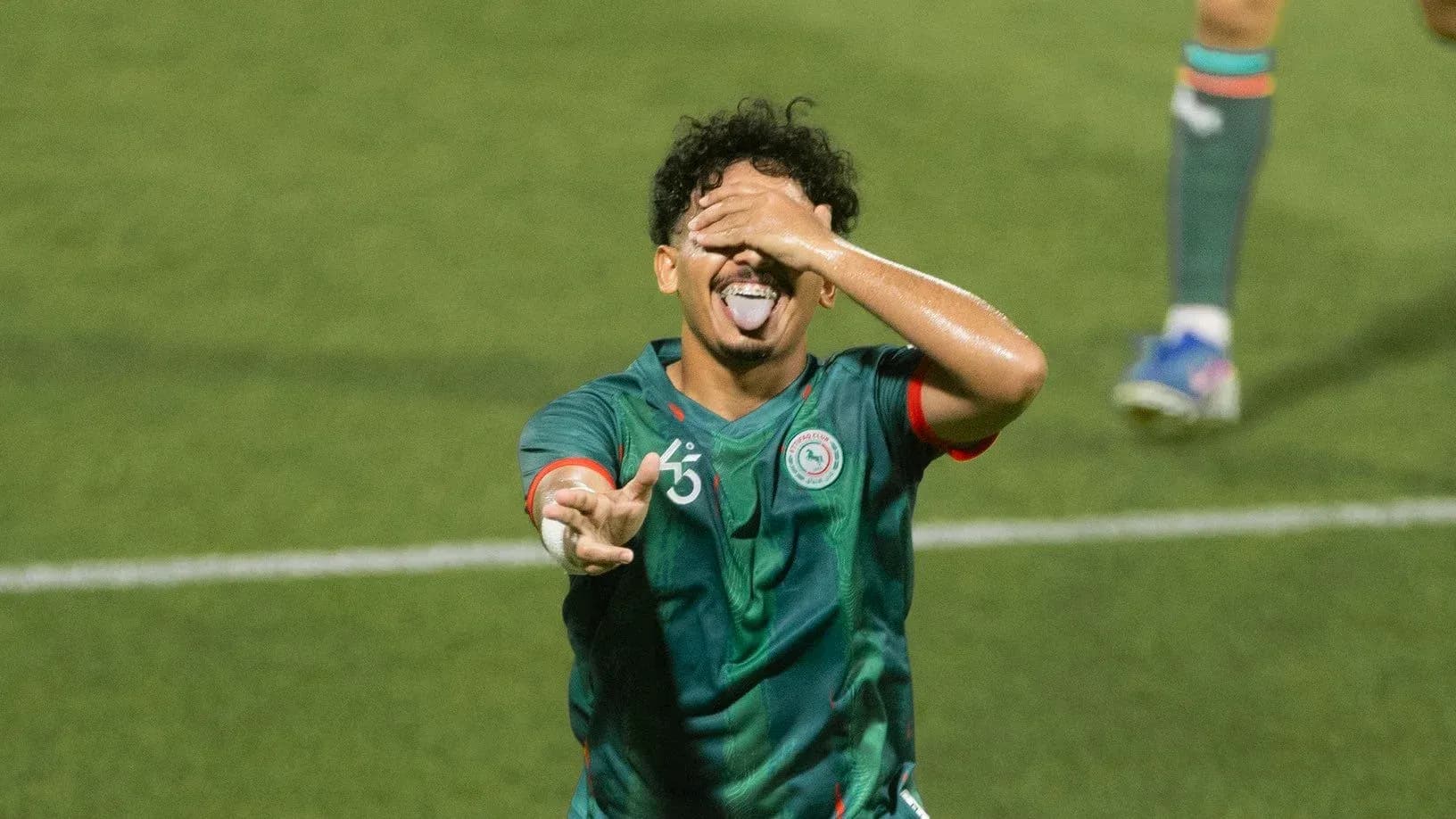 Jugador celebrando con gesto divertido en el campo