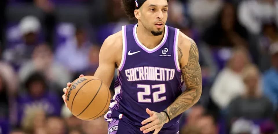 Jugador de baloncesto driblando con balón en partido