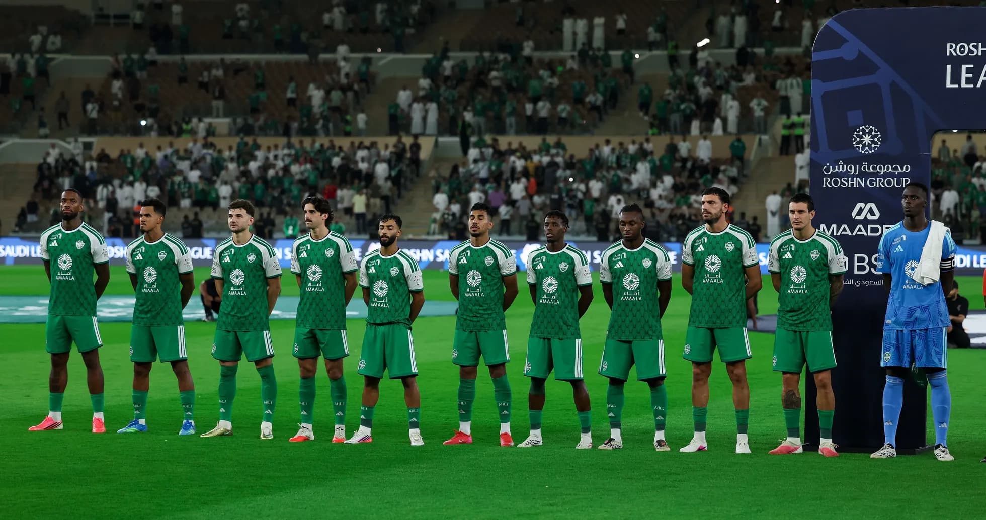 Equipo de fútbol alineado en el campo antes del partido