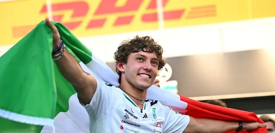 Piloto sosteniendo una bandera italiana en celebración