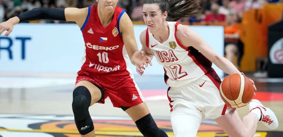 Jugadora de USA driblando mientras es defendida