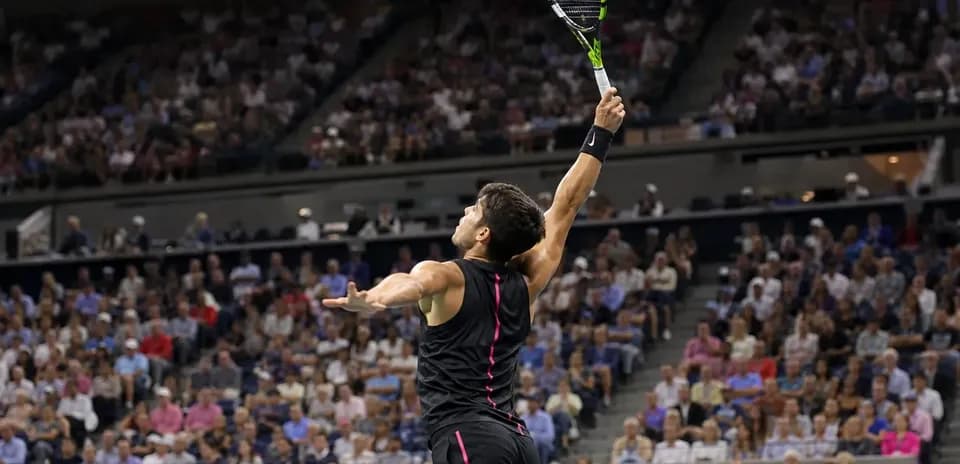 Jugador de tenis sacando en un partido lleno de público