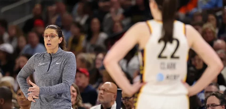 Entrenadora dirigiendo a jugadora en partido de baloncesto