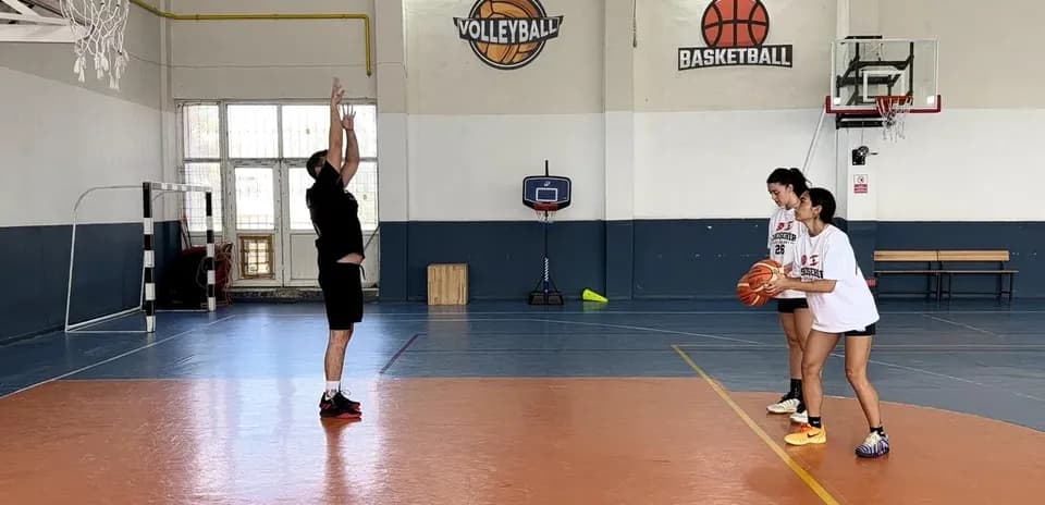 Entrenador enseñando técnica de tiro a jugadoras