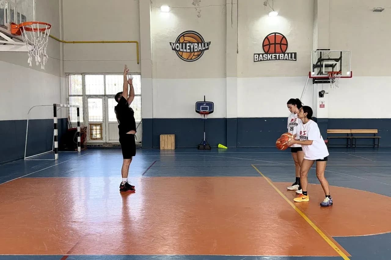 Entrenador enseñando técnica de tiro a jugadoras