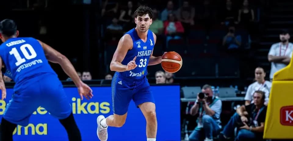 Jugador de baloncesto israelí driblando con balón