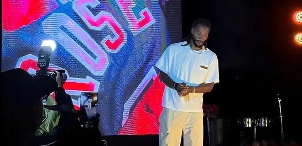 Artista en escenario con fondo iluminado y cámara