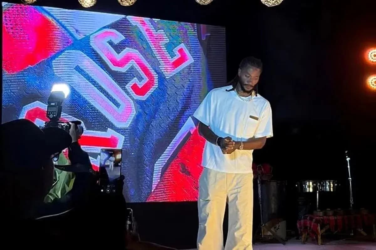 Artista en escenario con fondo iluminado y cámara
