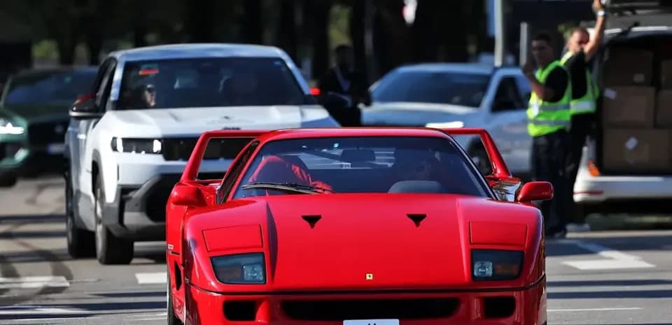 Ferrari roja avanzando entre otros vehículos en la calle