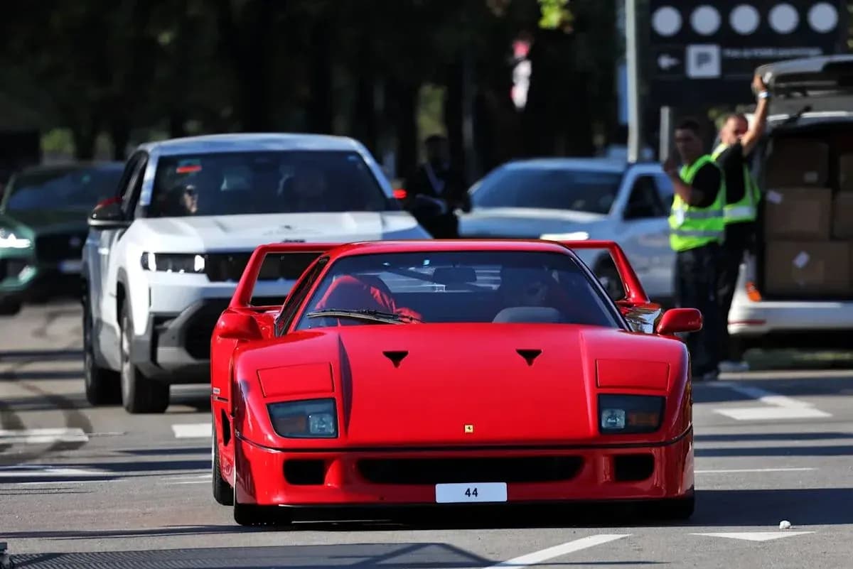 Ferrari roja avanzando entre otros vehículos en la calle