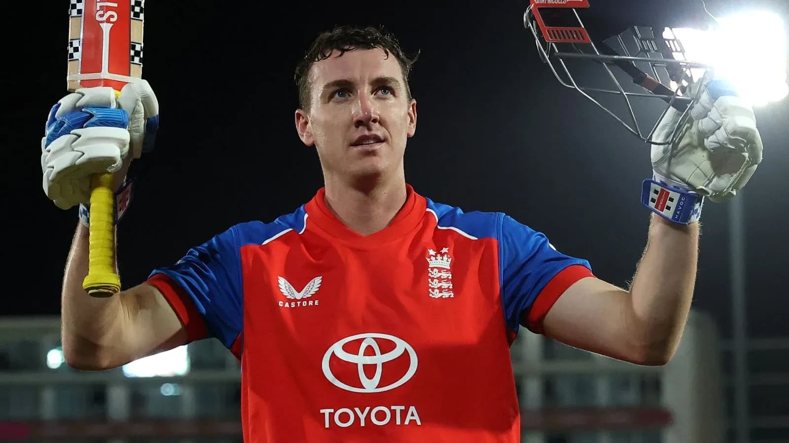 Jugador de cricket levantando su bate tras anotar runs
