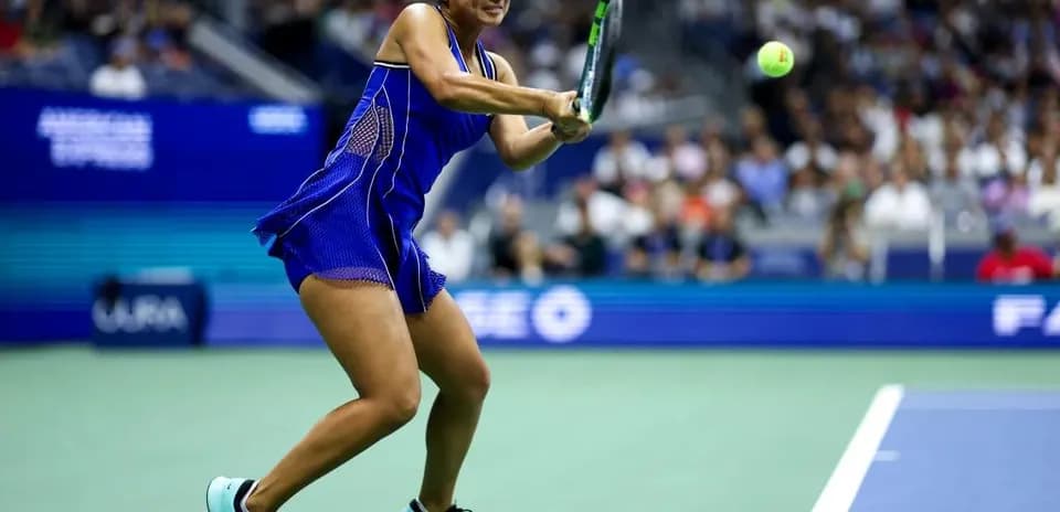 Jugadora golpeando la pelota en la cancha de tenis