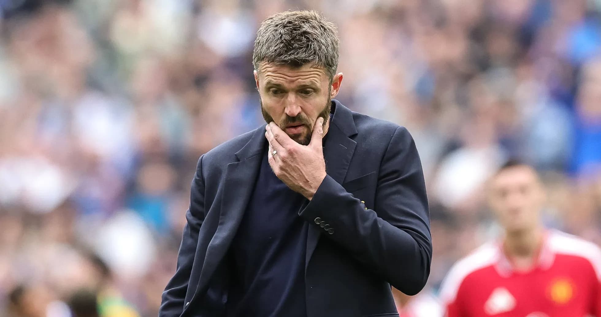 Entrenador pensativo durante un partido de fútbol