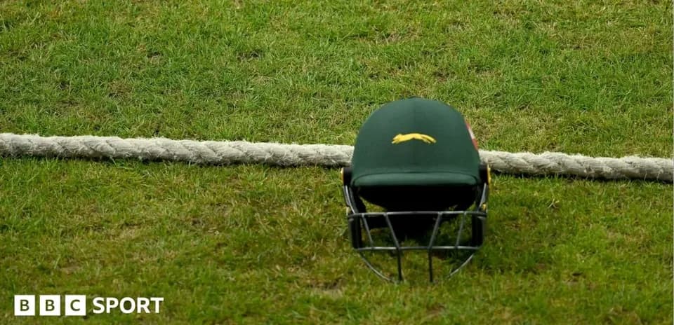 Casco de cricket sobre el césped junto a una cuerda