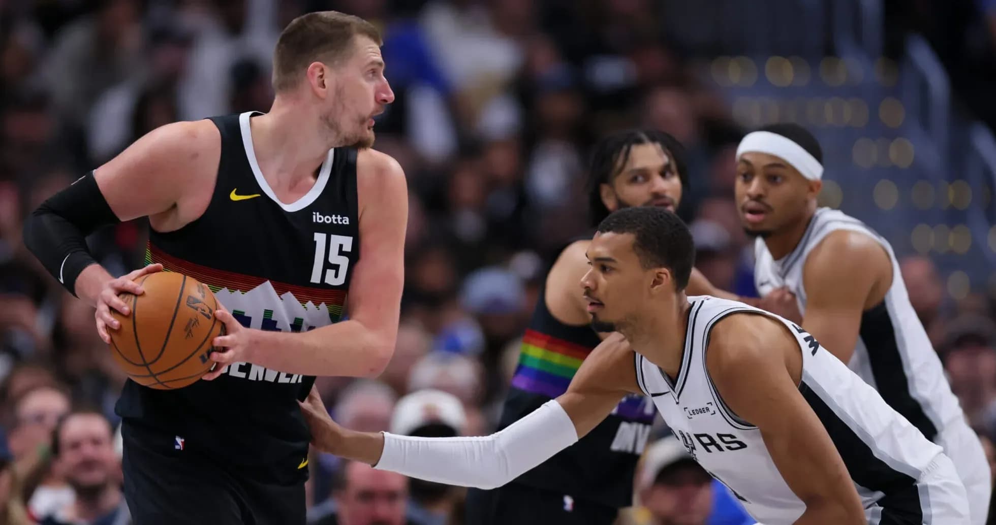 Jugador de Denver driblando mientras es defendido por San Antonio