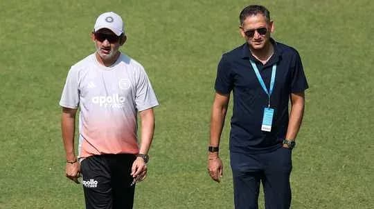 Dos entrenadores caminando por el campo de entrenamiento