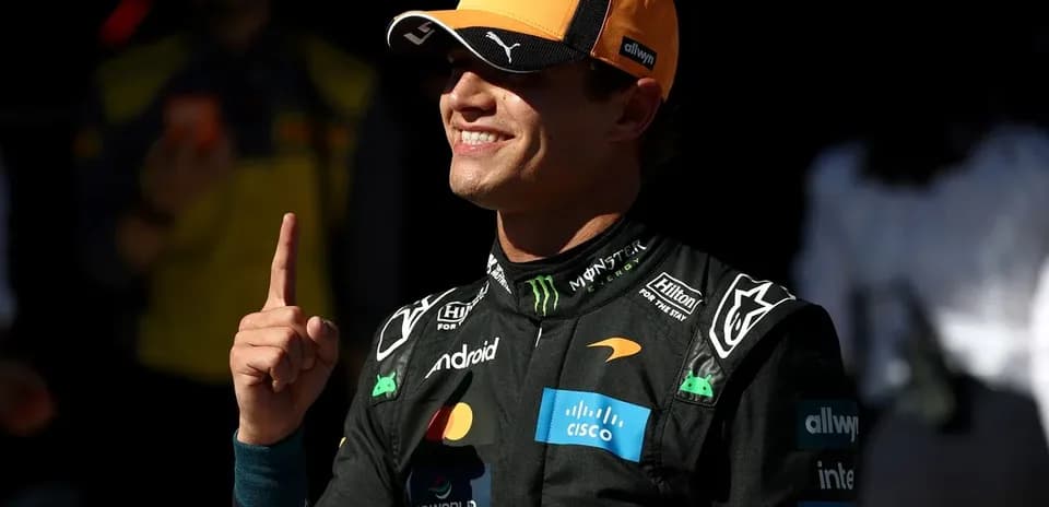 Piloto de McLaren señalando número uno en el garaje