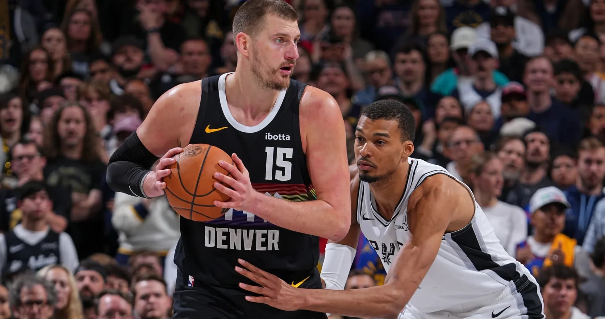 Jugador de Denver driblando mientras es defendido
