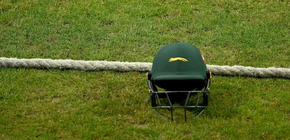 Casco de cricket sobre césped junto a cuerda