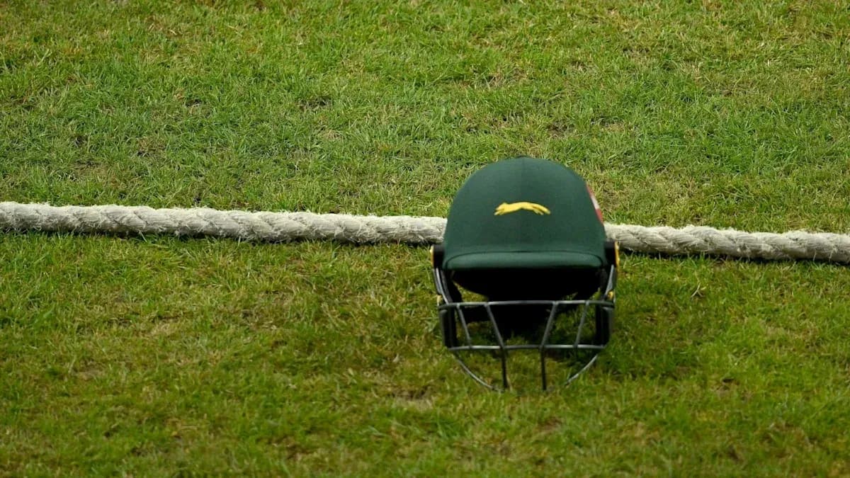 Casco de cricket sobre césped junto a cuerda