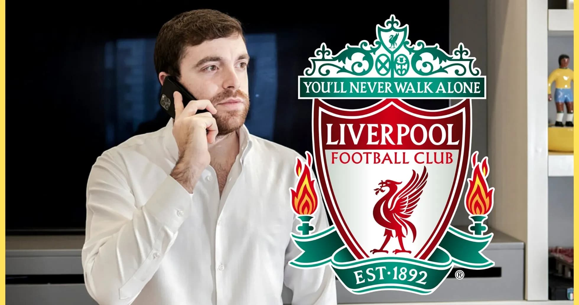 Hombre hablando por teléfono junto al escudo de Liverpool