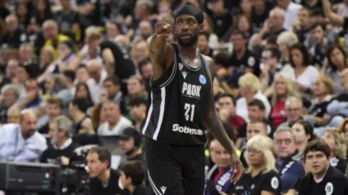 Jugador de baloncesto señalando en partido con afición