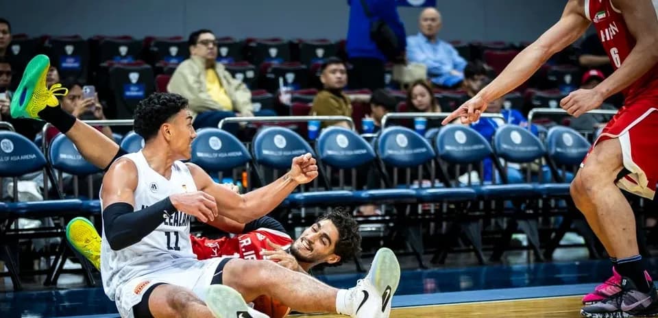 Jugadores en el suelo durante un partido de baloncesto