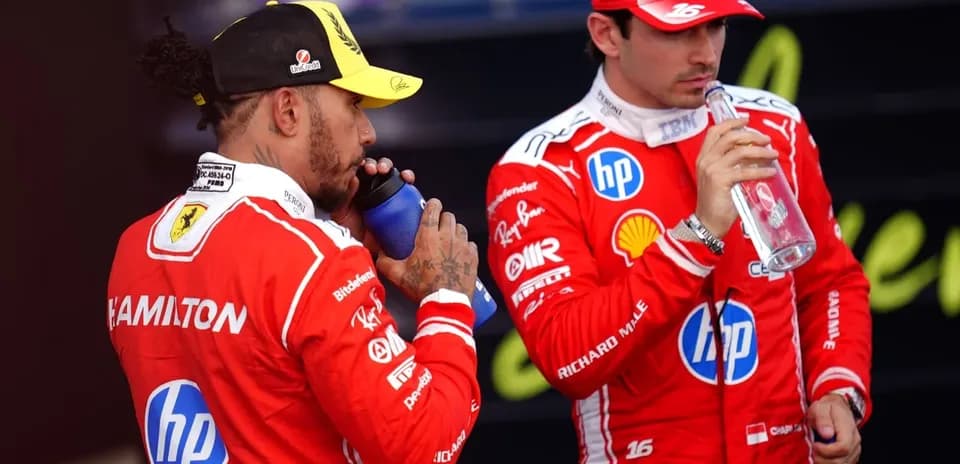 Dos pilotos bebiendo agua en el paddock