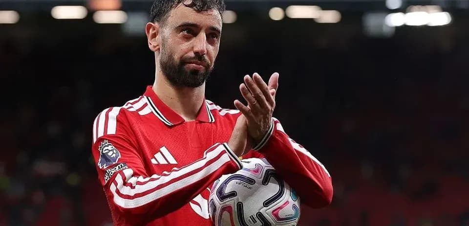 Jugador aplaudiendo con balón en mano en el campo