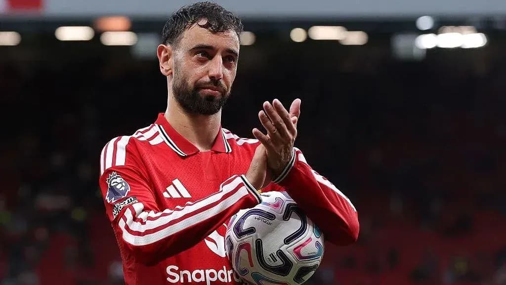 Jugador aplaudiendo con balón en mano en el campo