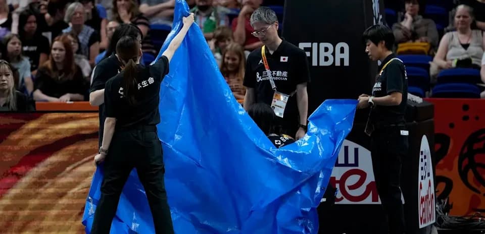Personal del evento colocando una lona azul en la cancha