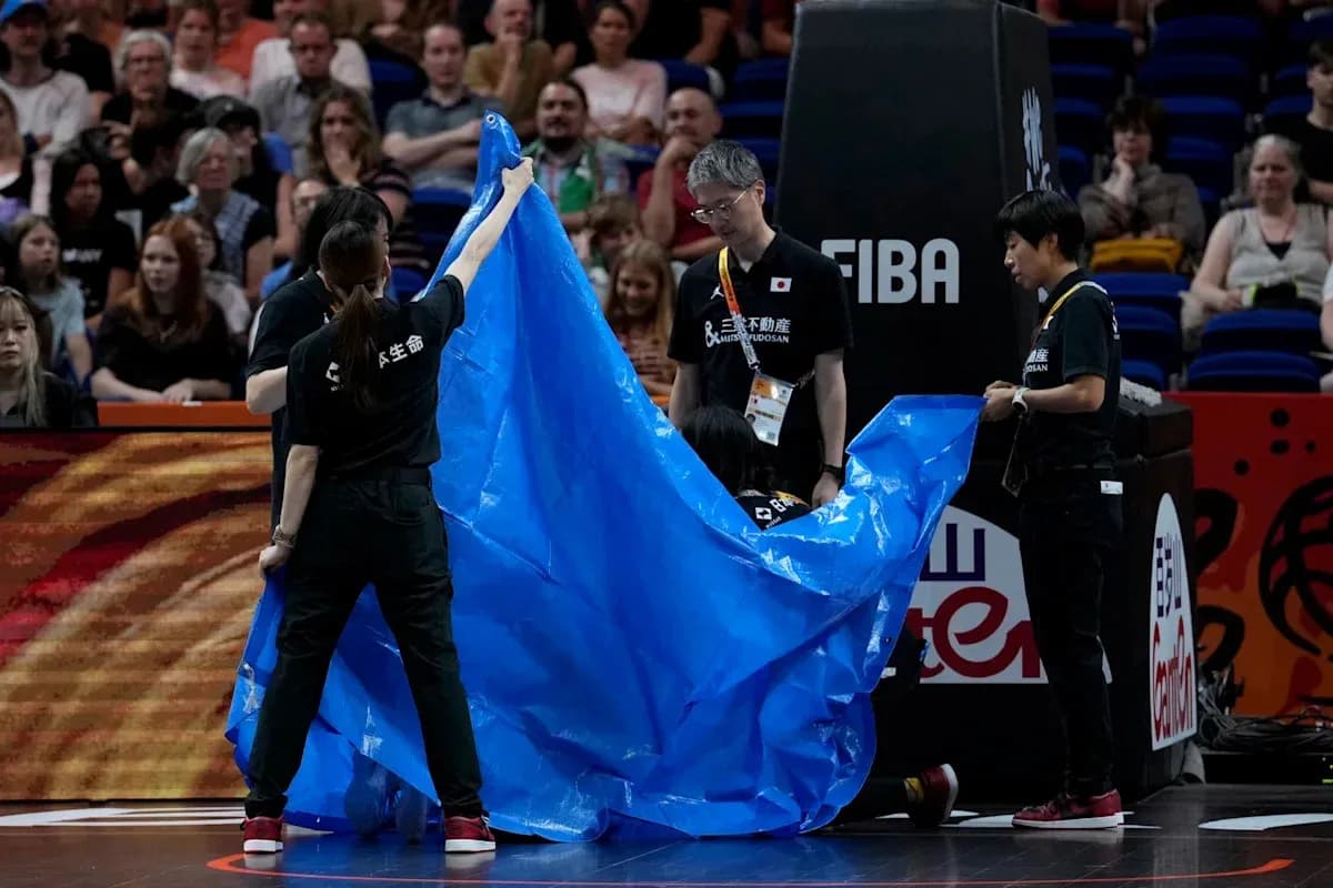 Personal del evento colocando una lona azul en la cancha