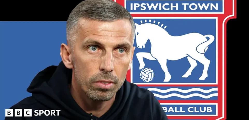 Entrenador hablando con fondo del escudo de Ipswich Town