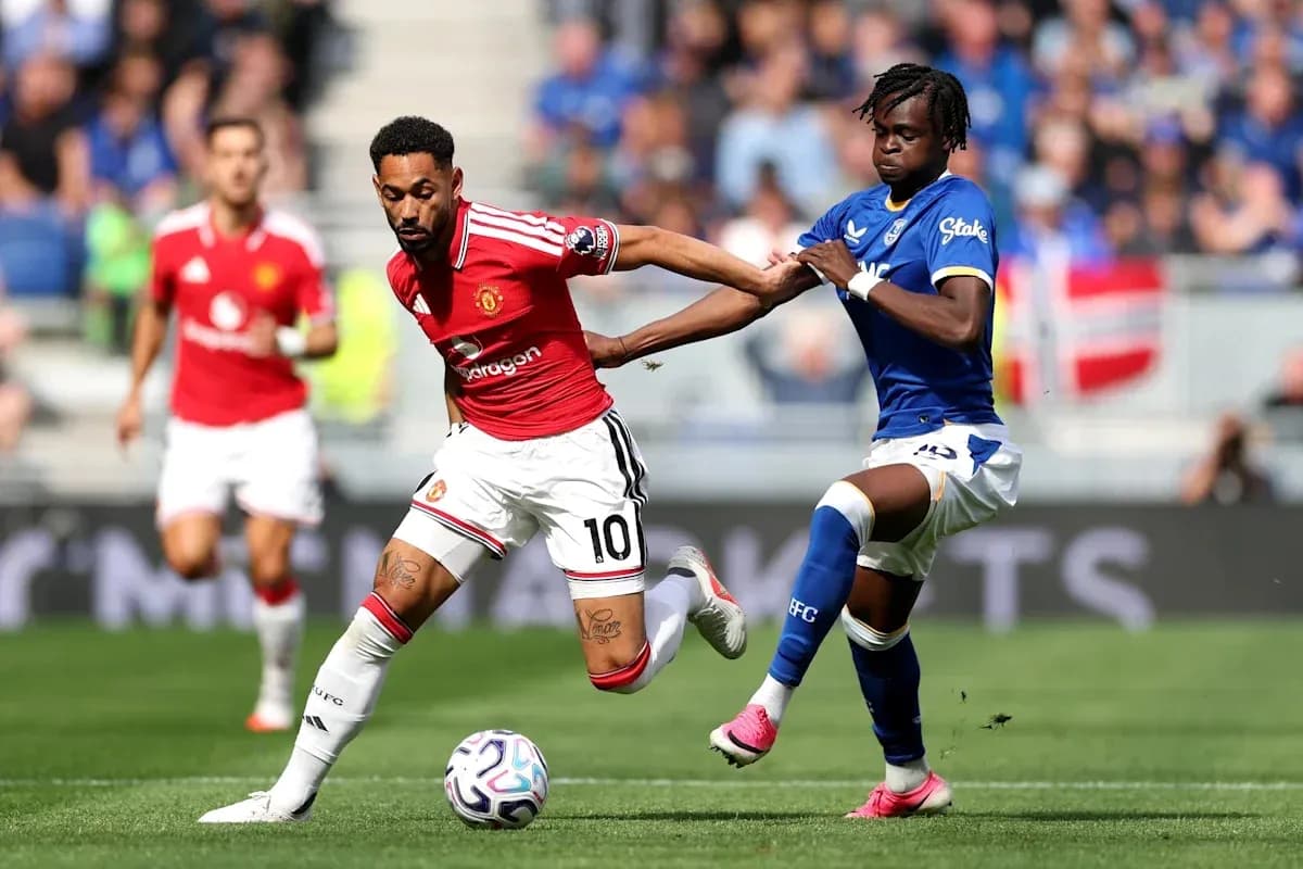 Jugador de Manchester United driblando ante rival de Everton