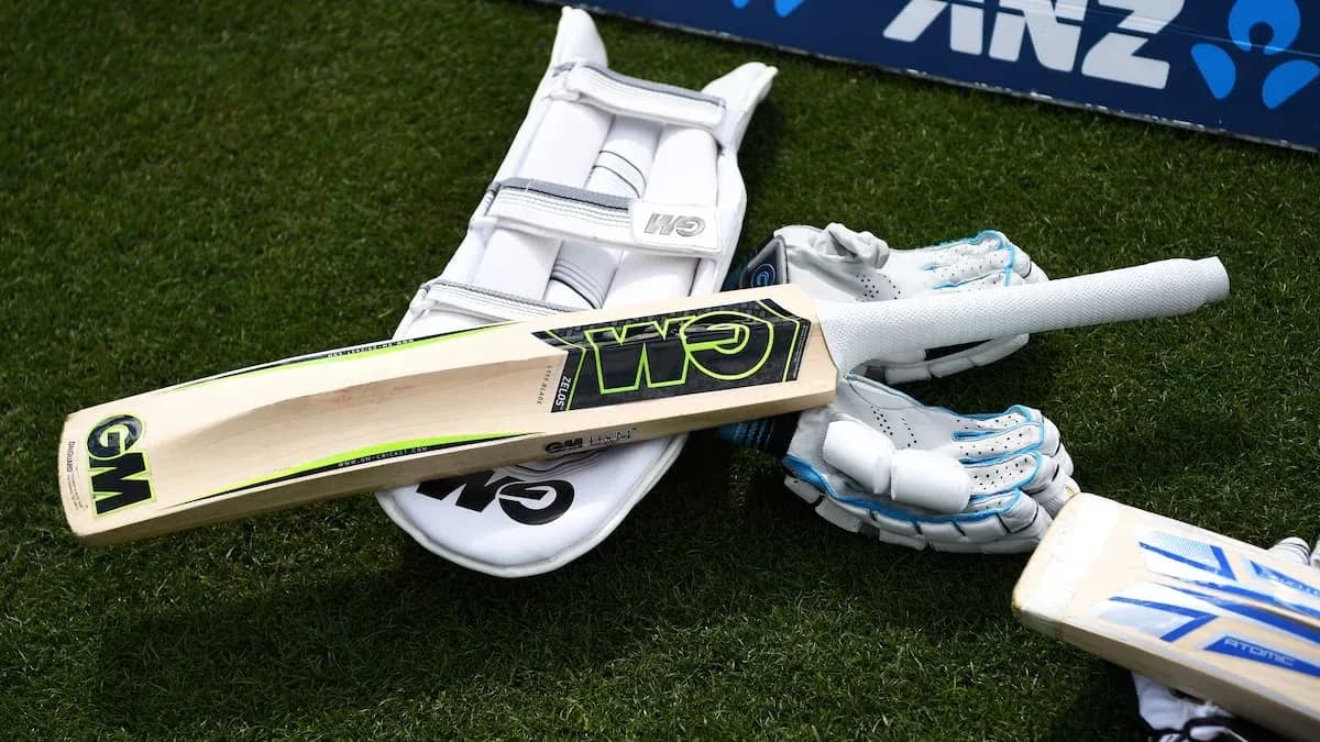 Equipo de cricket: bate, guantes y almohadilla en campo Equipo de cricket: bate, guantes y almohadilla en campo